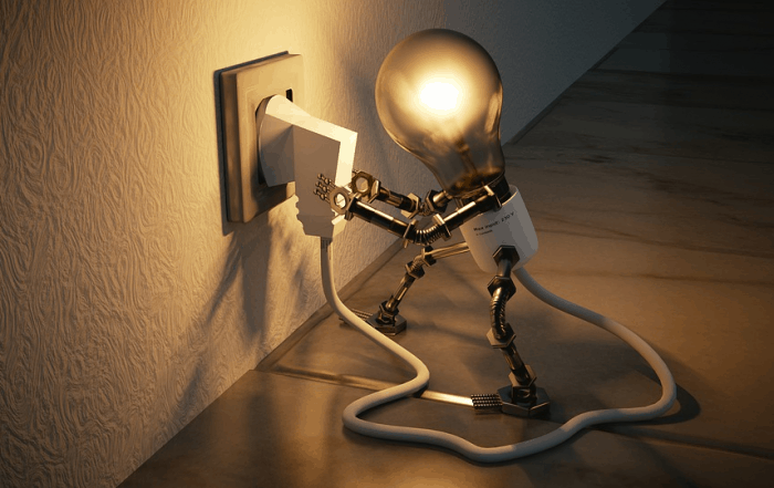 A personified lightbulb plugs itself in and lights up - finding joy in understanding what a wordpress plugin is and how plugins can help extend your site (with examples)