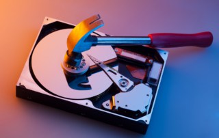 Image of hammer crushing disk drive to illustrate data destruction